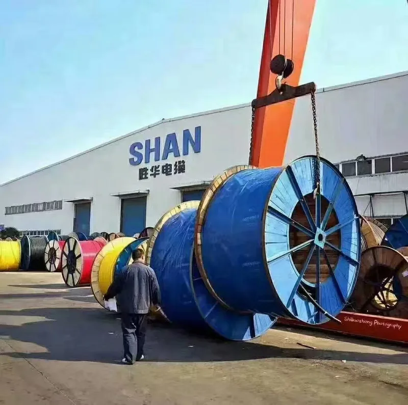 Workshop frontage of a cable plant with a gantry crane lifting a large cable drum