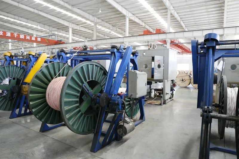 Large cable drum on a pay-off stand feeding a cable core