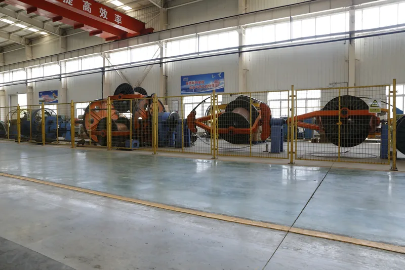 Rigid-frame stranding machine cages behind safety fencing