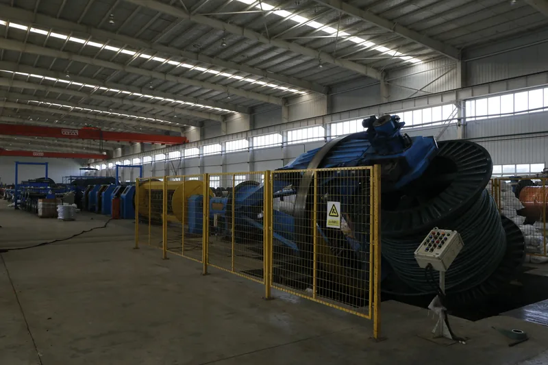 Finished cable drums stored behind safety fencing in the workshop