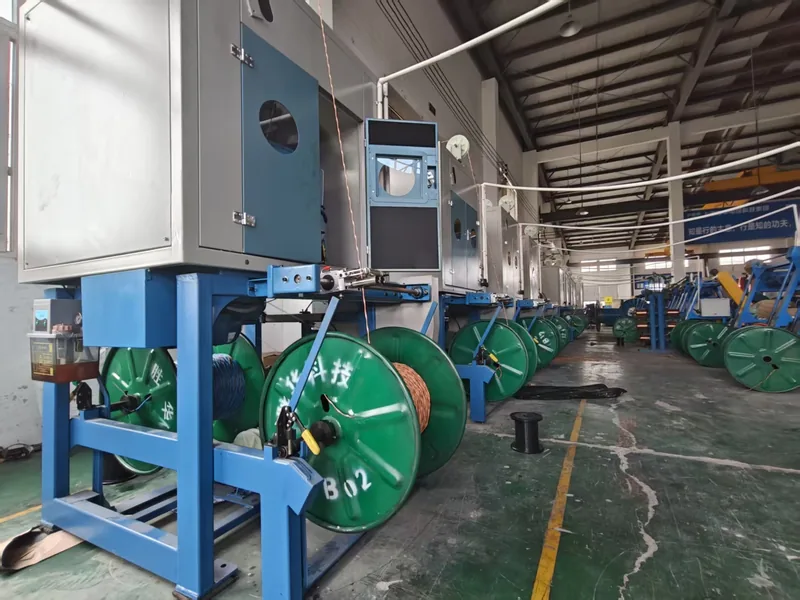 Row of blue-framed machines with green cable reels along a workshop line