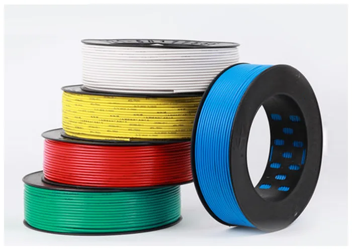 Stacked coils of wire in white, yellow, red, green and blue insulation beside a black coil