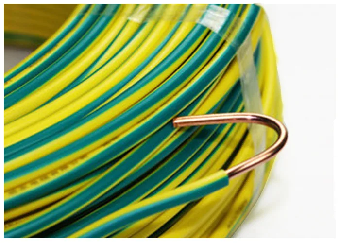 Coil of green-and-yellow insulated single-core wire with a length of bare copper conductor at the end