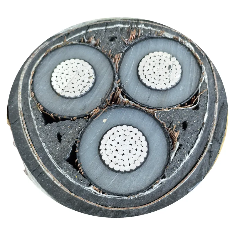 Cut end of a three-core cable — three round cores with silver-coloured stranded conductors under a dark layer and a light grey layer, copper strands in the fillers between them, and a black oversheath